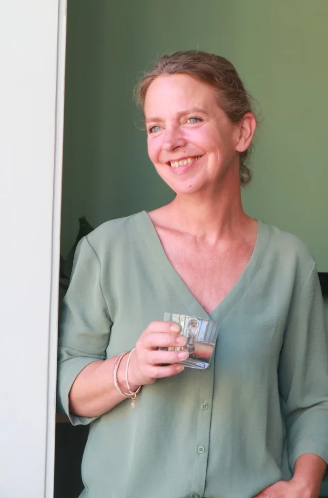 Karin van Brugge van Luistervink, lachend in de deuropening